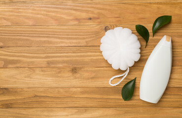 Fototapeta na wymiar Shower gel with washcloth on wooden background, top view