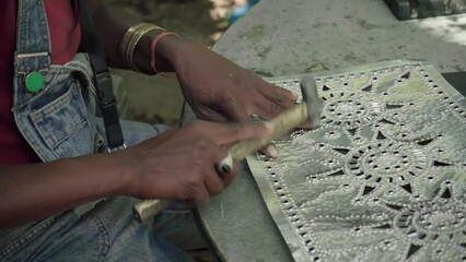 close up of a metal worker flipping over a small aluminium sheet