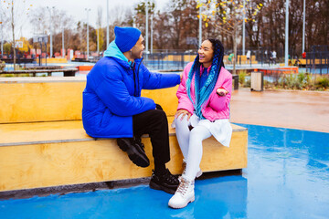 Multiracial young couple of lovers wearing winter jackets dating outdoors in winter
