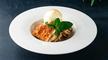 Pieces of honey cake with ice cream and mint.