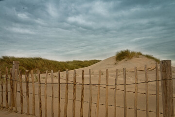 Sandd&uuml;ne mit einem Lattenzaun im Vordergrund
