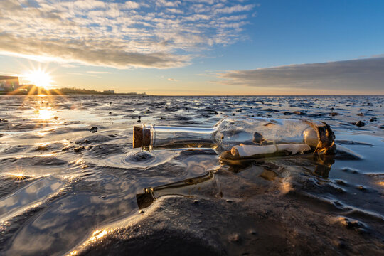 bottle post in the Wadden Sea at sunset