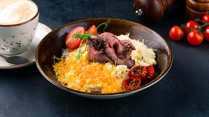 Scramble eggs with cheese, cherry tomatoes, beef, microgreens and cup of coffee.