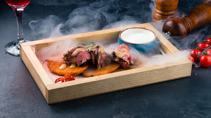 Potato pancakes with roast beef, cherry tomatoes and sauce.