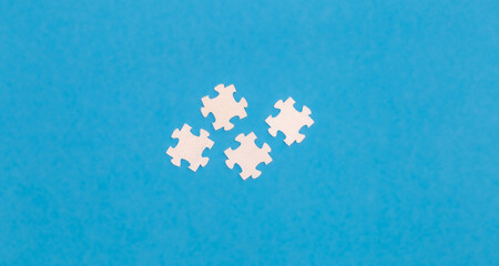 White puzzles on a blue background, flat lay.