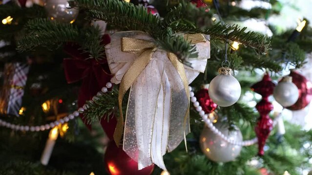 Nahaufnahme mit Makro Objektiv zeigt Details eines geschm&uuml;ckten Weihnachtsbaums. Unsch&auml;rfe wird scharf und zeigt edle Schleife aus Spitzenstoff. Endlosschleife.