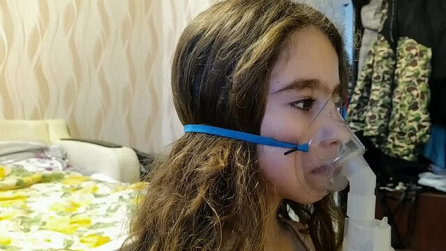 little girl with long hair breathes through an inhaler