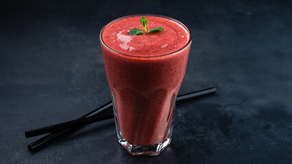 Strawberry and mint smoothie in a transparent glass goblet.