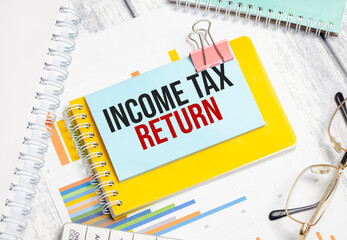 income tax return words on blue sticker with glasses