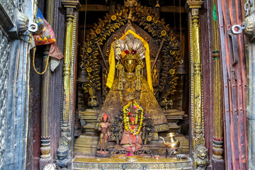 Small old golden Buddha statue in Yashodhar Mahabihar buddhist temple in Lalitpur city, Nepal. Religious symbols theme.