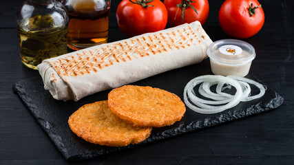 Fresh grilled shawarma with ham, pork, cabbage, pita bread, potato pancakes, onion and sauce.