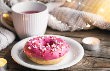 Cozy composition with donut and cup of tea.