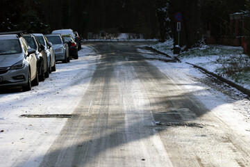 Zaśnieżona droga w mieście uwaga ślizgo na jezdni po opadach śniegu.  - obrazy, fototapety, plakaty