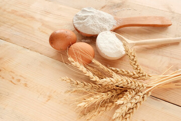 Wheat, grain, grain sack, ears of corn on a wooden background. Rolling pin, eggs, flour - ingredients for making flour products. The concept of farming, natural products.