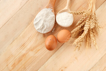 Wheat, grain, grain sack, ears of corn on a wooden background. Eggs, flour - ingredients for making flour products. The concept of farming, natural products.