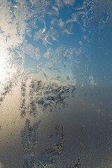 Frozen surface with icy pattern on window glass in cold winter day