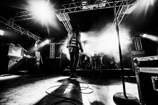 Musician on stage during a live concert. The punk bands vocalist walks the stage during the show.
