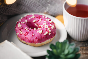 Cozy composition with donut and cup of tea.