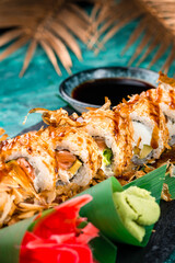 Sushi rolls with salmon, cream cheese, avocado in dry shavings of tuna, wasabi, ginger and soy sauce.