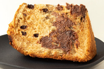 Sliced panettone stuffed with chocolate on plate.