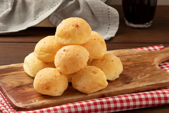 Focus on a pile of cheese bread on cutting board.
