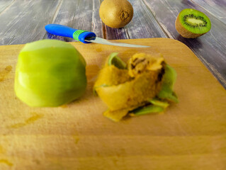 Peeled tropical kiwi fruit on a wooden board. Half kiwi. Close up 