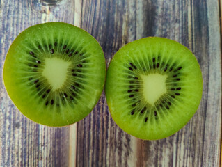 Two half kiwi fruit. Tropical green fruit on a wooden table. Close up 