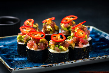 Sushi rolls with raw tuna, cream cheese, avocado and chili peppers.