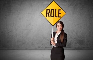 Young business person holding road sign