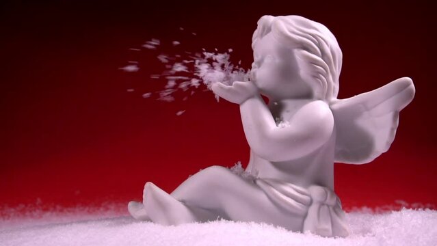 Christmas Porcelain Angel blowing snow with red background