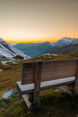 wooden bench during sunset in the alps (Carschinahütte, Grisons, Switzerland)