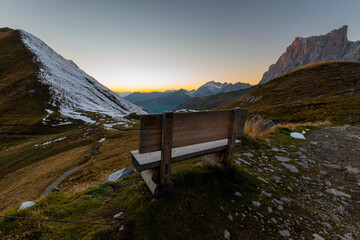 wooden bench during sunset in the alps (Carschinahütte, Grisons, Switzerland)