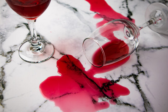 Overturned Glass And Spilled Wine On Marble Table