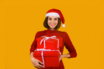 Happy excited young woman in santa hat with gift boxes