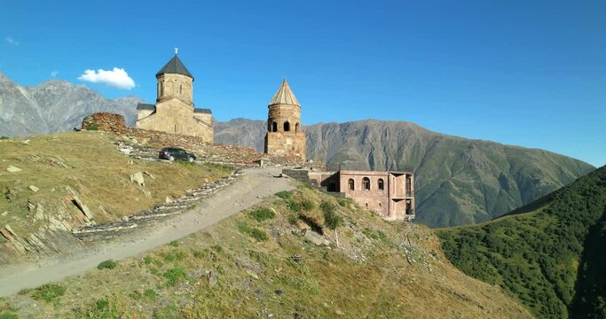 Trinity Church in Gergeti in Georgia, aerial view. Monastery in the Caucasus Mountains. The church at the foot of Mount Kazbek. The monastery on Kazbek. 