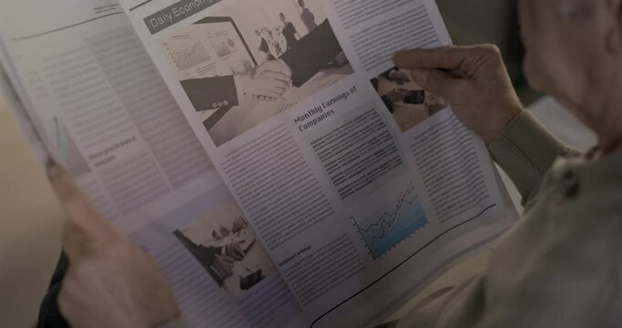 Old man reading the newspaper at home