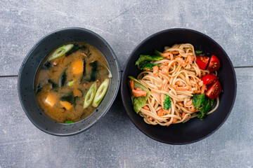Lunch udon noodles with salmon and tomatoes and miso soup with tofu, seaweed, onions and shiitake...