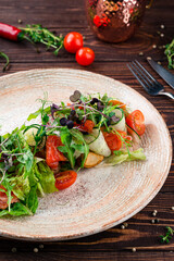 Fish salad with salmon, fried potatoes, poached egg, cherry tomatoes, lettuce, microgreens, arugula and dressing.