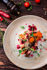 Fried duck fillet with parsnip puree, lingonberry sauce, sweet potato chips, herbs and pine nuts.