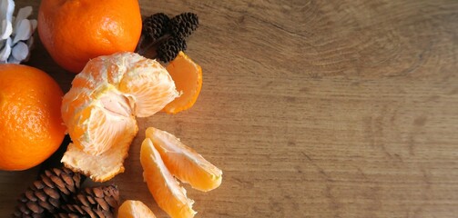 Tangerines next to cones on a wooden table