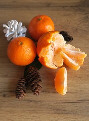 Tangerines next to cones on a wooden table