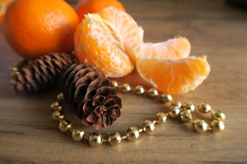 Tangerines next to cones on a wooden table