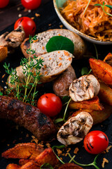 Grilled pork and chicken sausages with rustic baked potatoes, tomatoes, mushrooms, stewed cabbage, bread and rosemary.