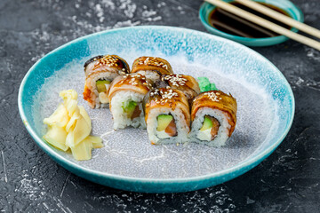 roll Canada with eel, salmon and avocado on a grey table