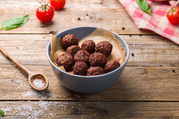 meatballs in bowl on wooden table side view