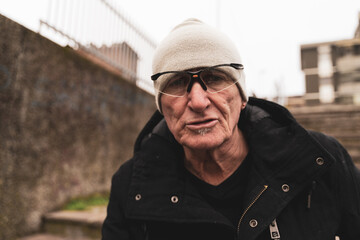 mature man rap singer posing in the street on the outskirts of a city