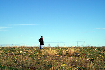 Pastore solitario di un greggio di pecore col bastone in campagna
