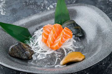 Sashimi salmon on a plate on a grey table