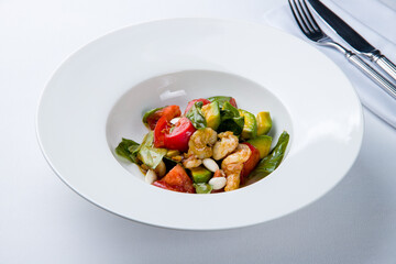 salad with shrimp, avocado and tomatoes on a white plate