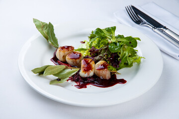 grilled scallop with berry sauce on a white plate